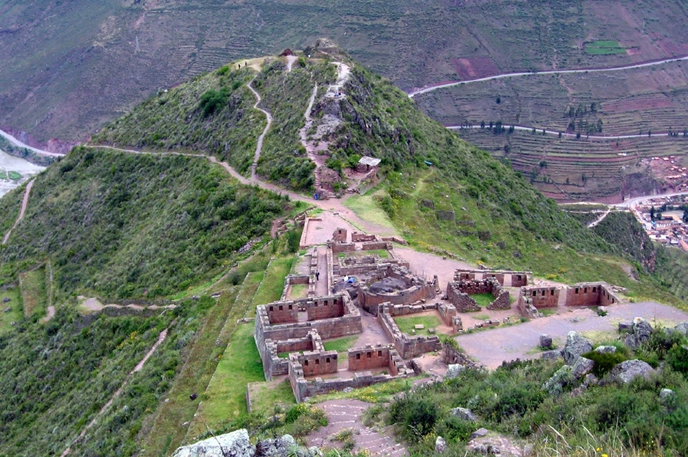 Panoramic view of the Pisac ruins in the Sacred Valley, Peru, showcasing ancient Inca terraces and surrounding Andean mountains.